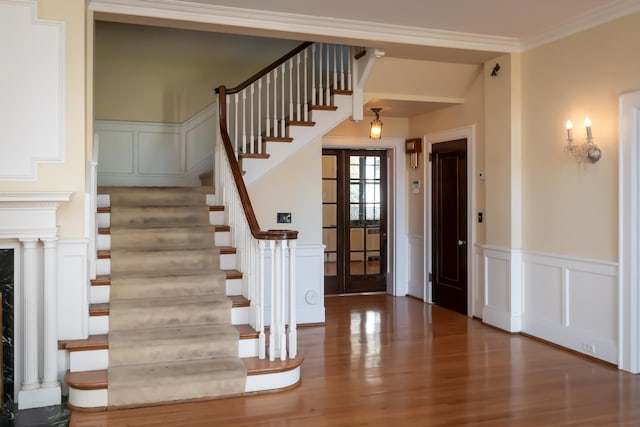 entrance foyer featuring wood-type flooring, french doors, and ornamental molding