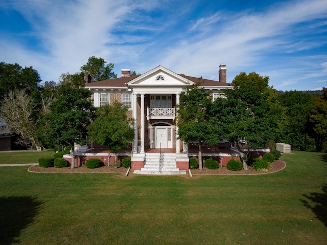 greek revival inspired property with a front yard