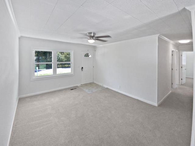 spare room featuring light carpet, ornamental molding, and ceiling fan