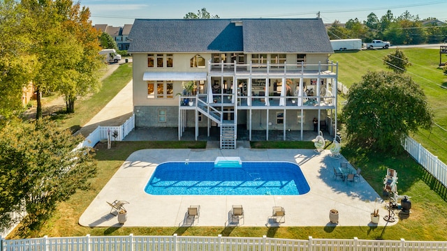 rear view of property with a patio area, a balcony, and a fenced in pool