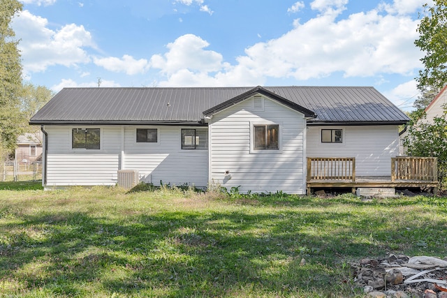 rear view of property featuring a wooden deck and a yard