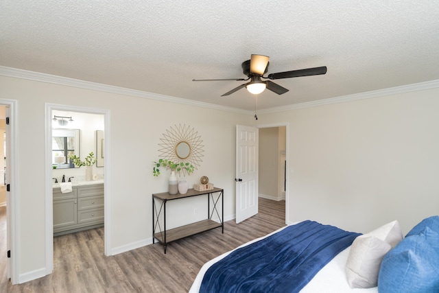 bedroom with crown molding, light hardwood / wood-style flooring, ceiling fan, and ensuite bath