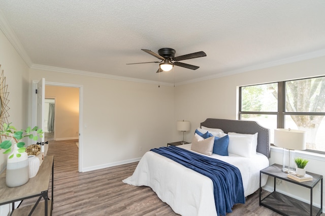 bedroom with ornamental molding, a textured ceiling, wood-type flooring, and ceiling fan