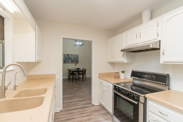 kitchen with sink, white cabinetry, light hardwood / wood-style flooring, and electric stove