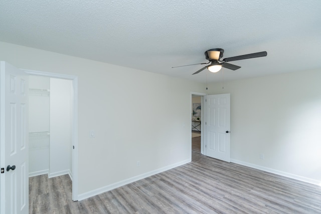 unfurnished room featuring light hardwood / wood-style flooring, a textured ceiling, and ceiling fan