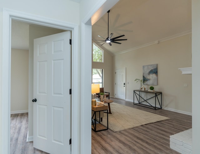 hallway with ornamental molding, hardwood / wood-style floors, and vaulted ceiling