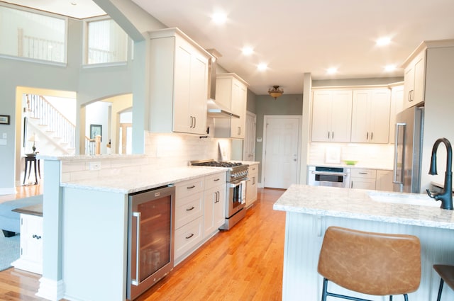 kitchen featuring wine cooler, white cabinetry, and premium appliances