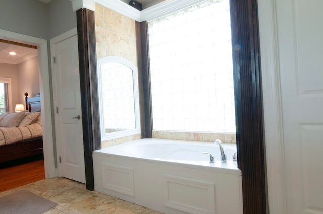 bathroom featuring ornamental molding and a bathtub