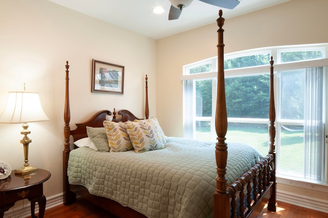 bedroom with multiple windows, dark hardwood / wood-style floors, and ceiling fan