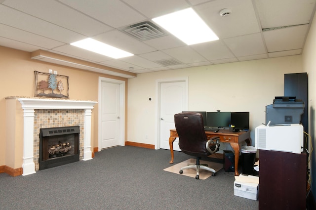 office space with a drop ceiling, a fireplace, and carpet flooring