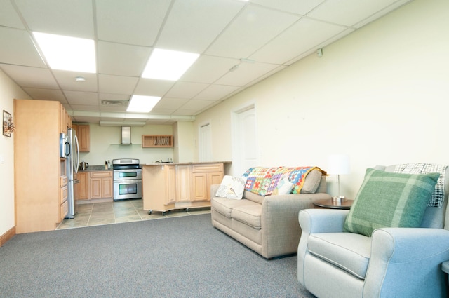 living room with a drop ceiling and light colored carpet