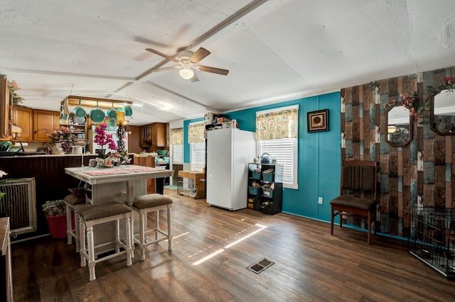 kitchen featuring white fridge, ceiling fan, vaulted ceiling, and dark hardwood / wood-style floors