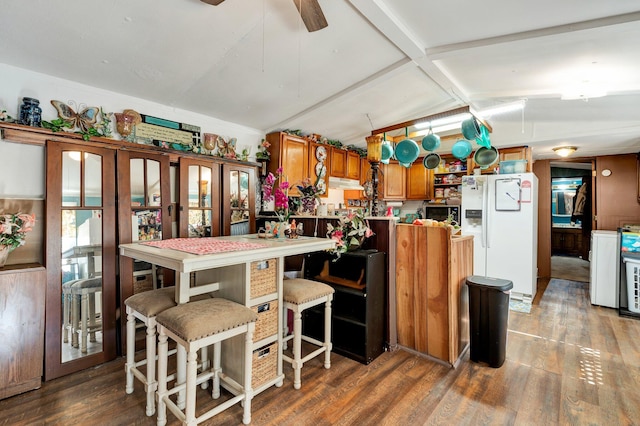 kitchen with white refrigerator with ice dispenser, vaulted ceiling with beams, and dark hardwood / wood-style flooring