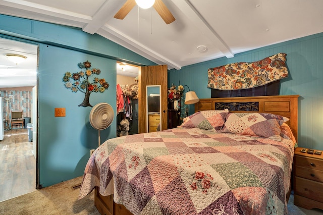 bedroom featuring ceiling fan, vaulted ceiling with beams, carpet floors, a closet, and a walk in closet