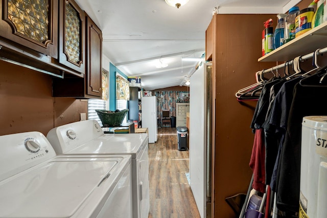 washroom with light wood-type flooring, water heater, washing machine and clothes dryer, ceiling fan, and cabinets