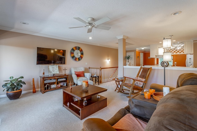 carpeted living room with ornamental molding, a textured ceiling, ornate columns, and ceiling fan