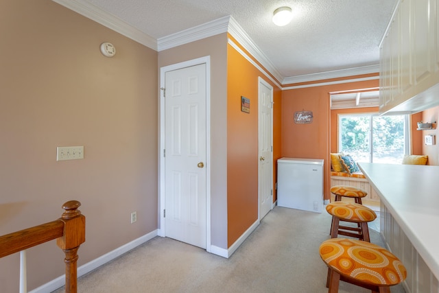 corridor with light carpet, a textured ceiling, and ornamental molding