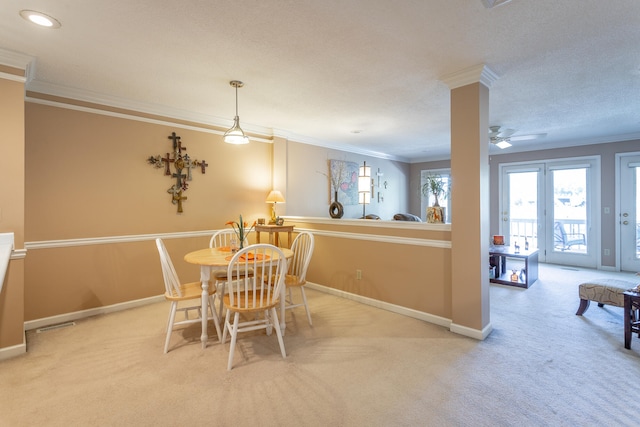 carpeted dining space with crown molding, a textured ceiling, and ceiling fan