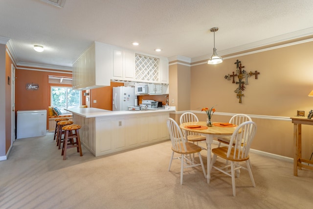 carpeted dining room featuring ornamental molding and a textured ceiling