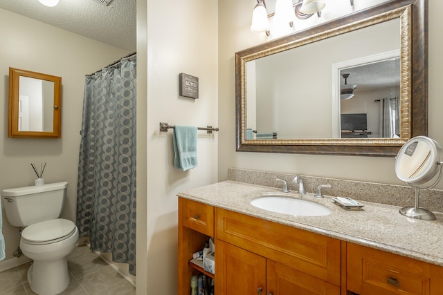 bathroom featuring vanity, toilet, tile patterned floors, and a textured ceiling