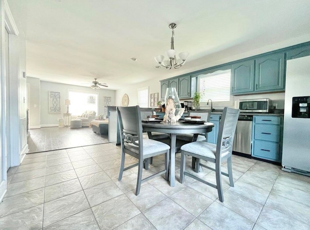 dining area featuring a wealth of natural light and ceiling fan with notable chandelier