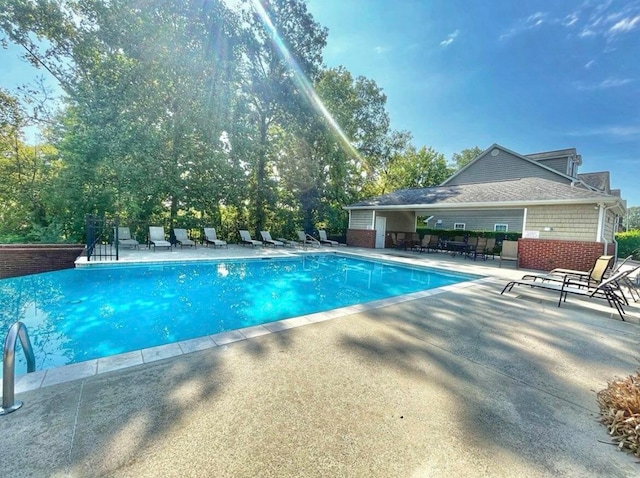 view of swimming pool featuring pool water feature and a patio