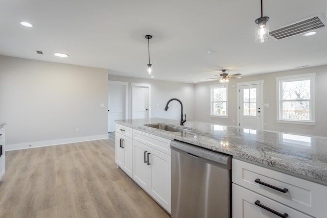 kitchen with visible vents, hanging light fixtures, stainless steel dishwasher, white cabinetry, and a sink