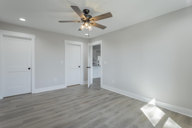 unfurnished bedroom with light wood finished floors, recessed lighting, a ceiling fan, and baseboards