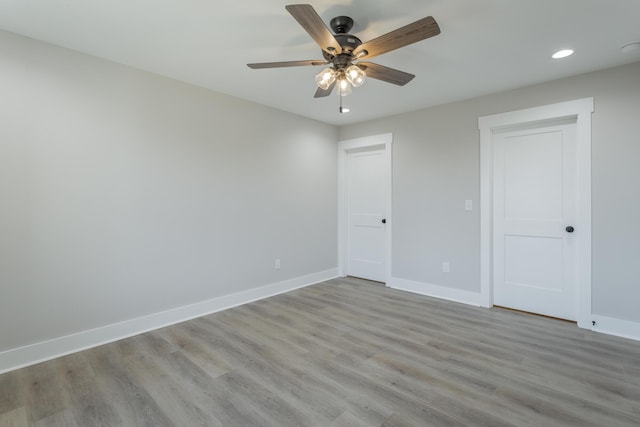 spare room featuring light wood-style floors, recessed lighting, and baseboards