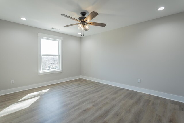 empty room with visible vents, light wood-style flooring, and baseboards