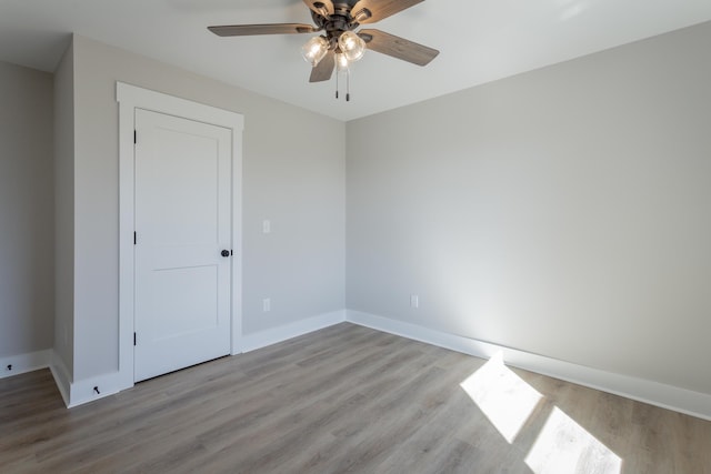 unfurnished room featuring light wood-type flooring, ceiling fan, and baseboards