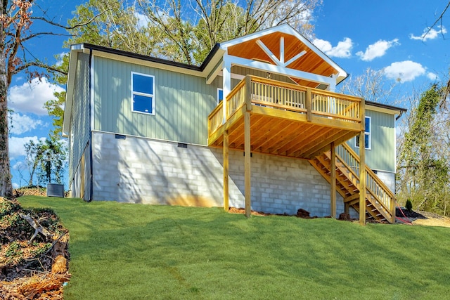 back of property featuring a garage, a lawn, stairway, a wooden deck, and central air condition unit