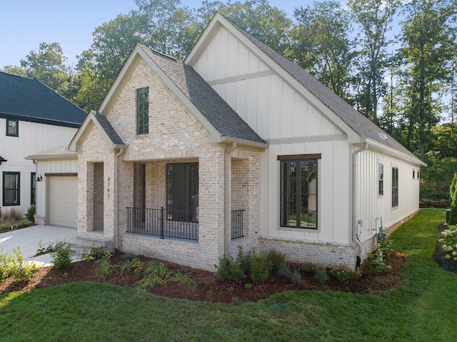 modern farmhouse featuring a porch, a front yard, and a garage