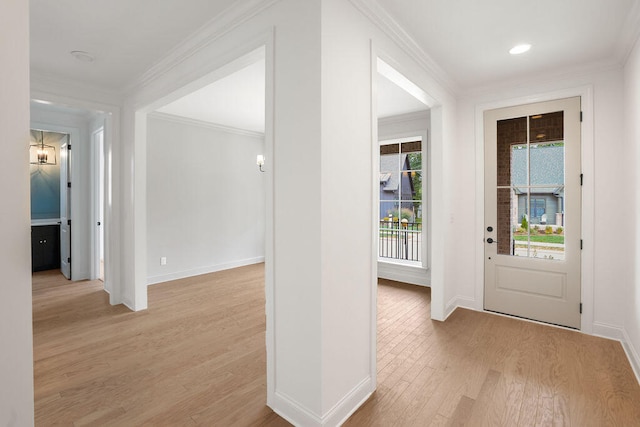 foyer with light wood-type flooring and crown molding