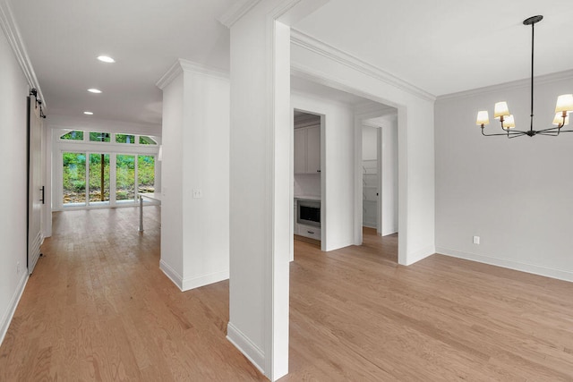 hallway featuring ornamental molding, a notable chandelier, and light wood-type flooring