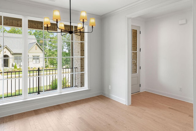 unfurnished dining area featuring light hardwood / wood-style floors, ornamental molding, and an inviting chandelier