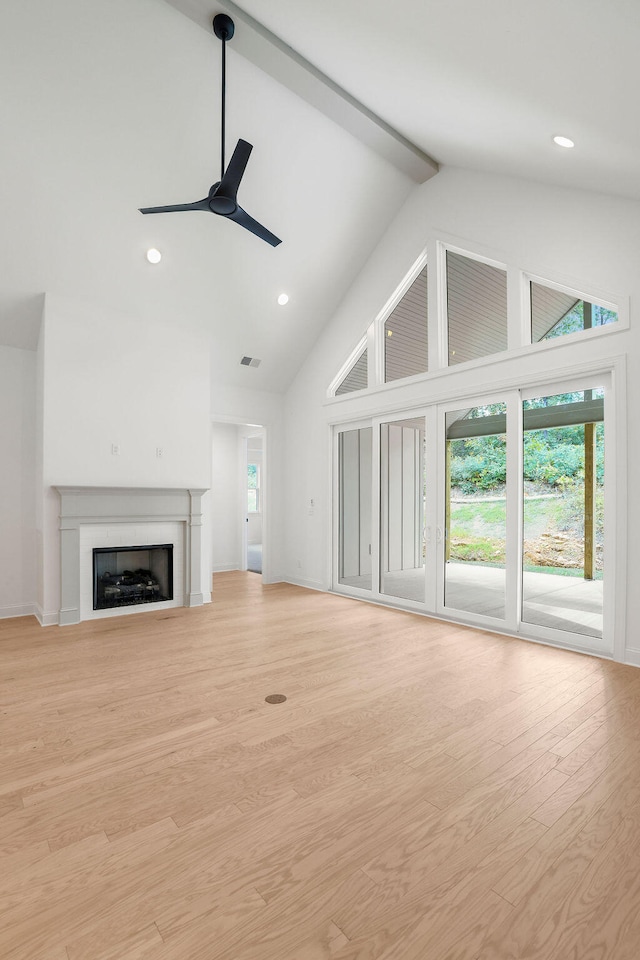 unfurnished living room featuring beam ceiling, ceiling fan, high vaulted ceiling, and light wood-type flooring