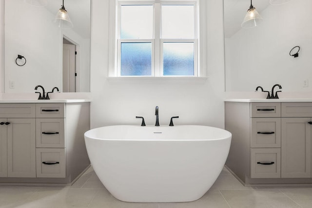 bathroom with tile patterned floors, vanity, and a bath