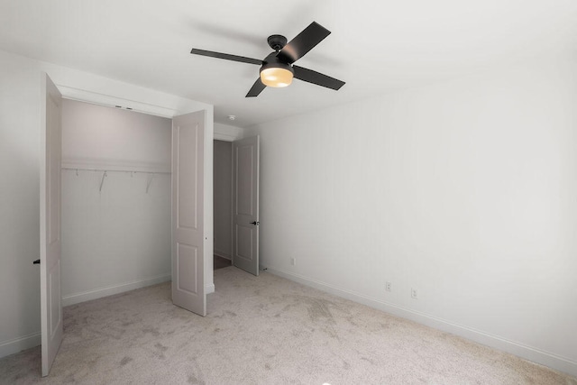 unfurnished bedroom with ceiling fan, light colored carpet, and a closet