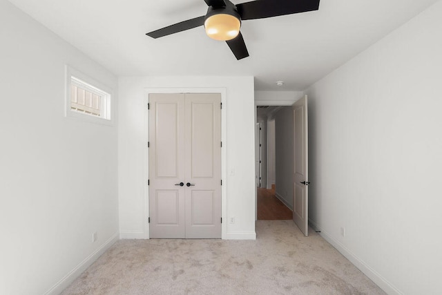 unfurnished bedroom with light carpet, a closet, and ceiling fan