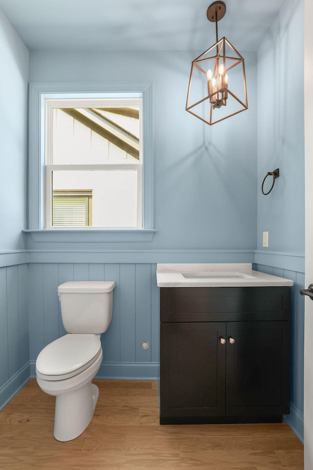 bathroom featuring toilet, vanity, a chandelier, and hardwood / wood-style flooring