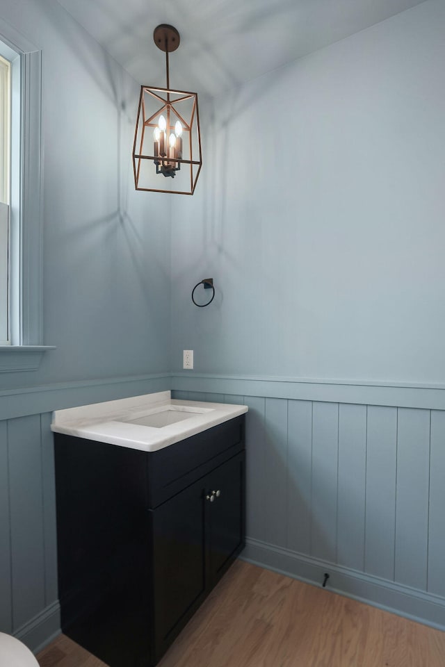 bathroom with hardwood / wood-style floors, vanity, and an inviting chandelier