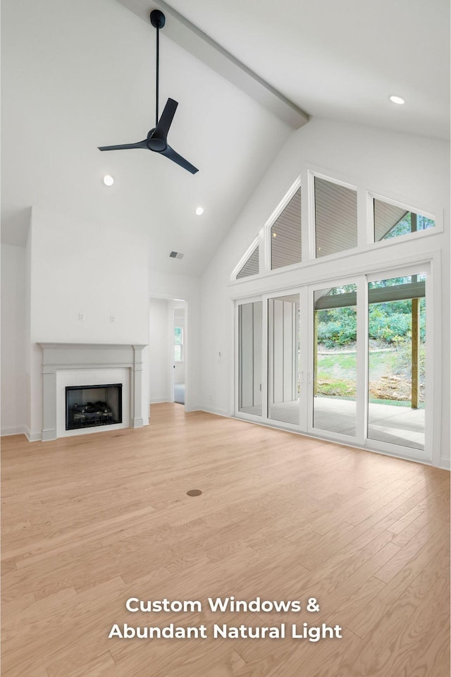 unfurnished living room featuring beamed ceiling, ceiling fan, light hardwood / wood-style floors, and high vaulted ceiling