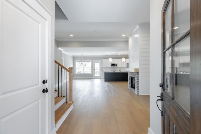 entrance foyer featuring ornamental molding and light wood-type flooring