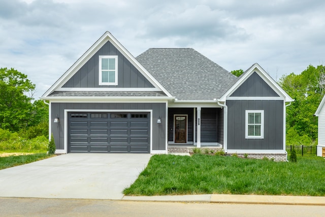 view of front of house with a porch, a front yard, and a garage