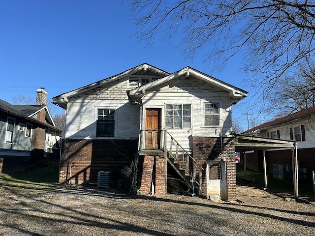 view of front of house with central air condition unit and a carport