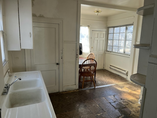 kitchen with a healthy amount of sunlight, white cabinetry, and a baseboard radiator