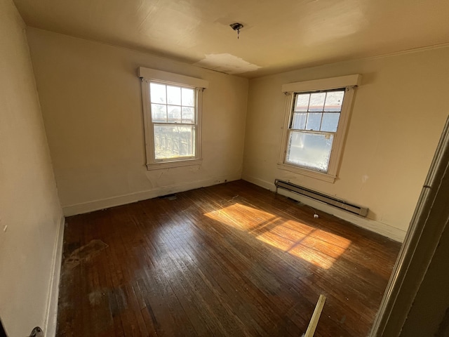 spare room with a baseboard radiator, dark hardwood / wood-style flooring, and plenty of natural light