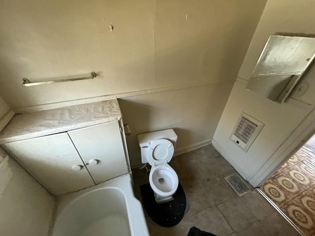 bathroom with toilet and tile patterned flooring