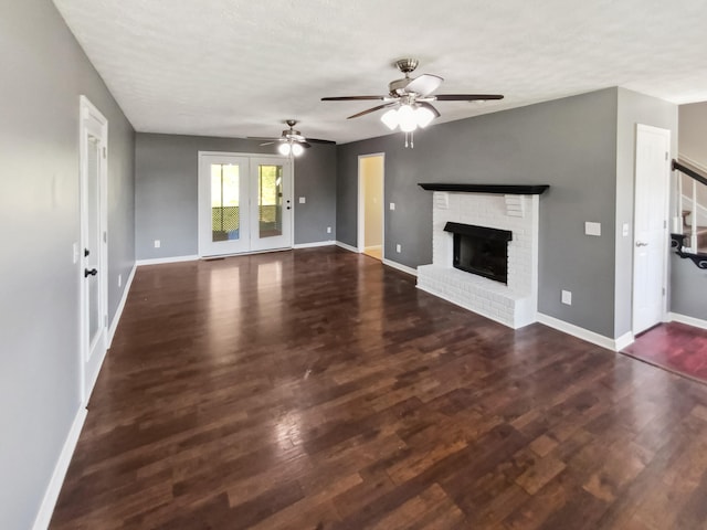 unfurnished living room featuring a textured ceiling, ceiling fan, a fireplace, and dark hardwood / wood-style flooring